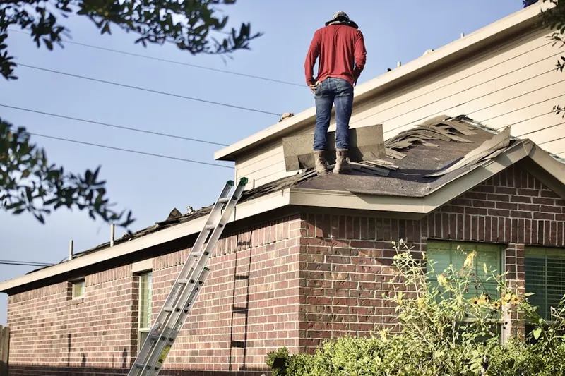 Professional roofer working on a residential roof in Klondike